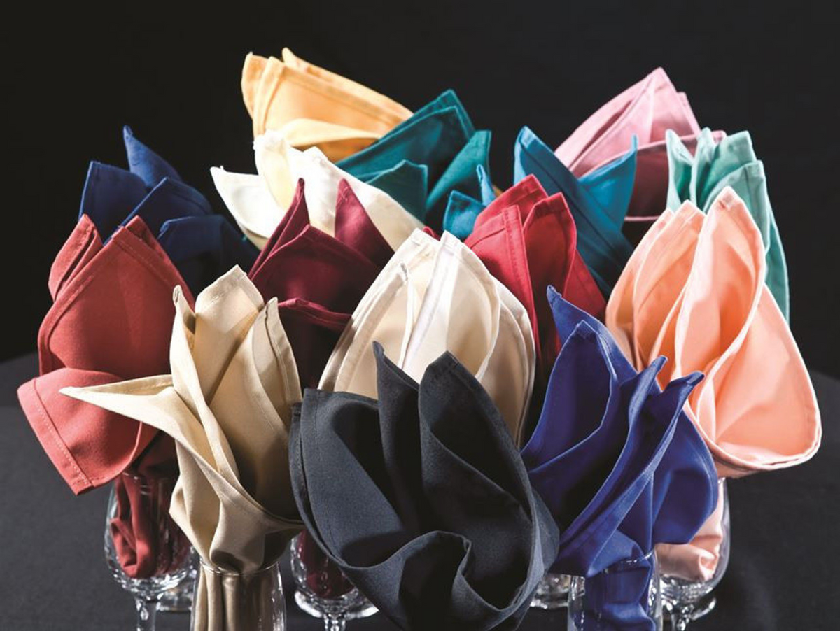 Premier Bay Circles 100% Polyester napkins by 1Concier, elegantly folded and upright in clear glasses, display their vibrant colors against a black background.