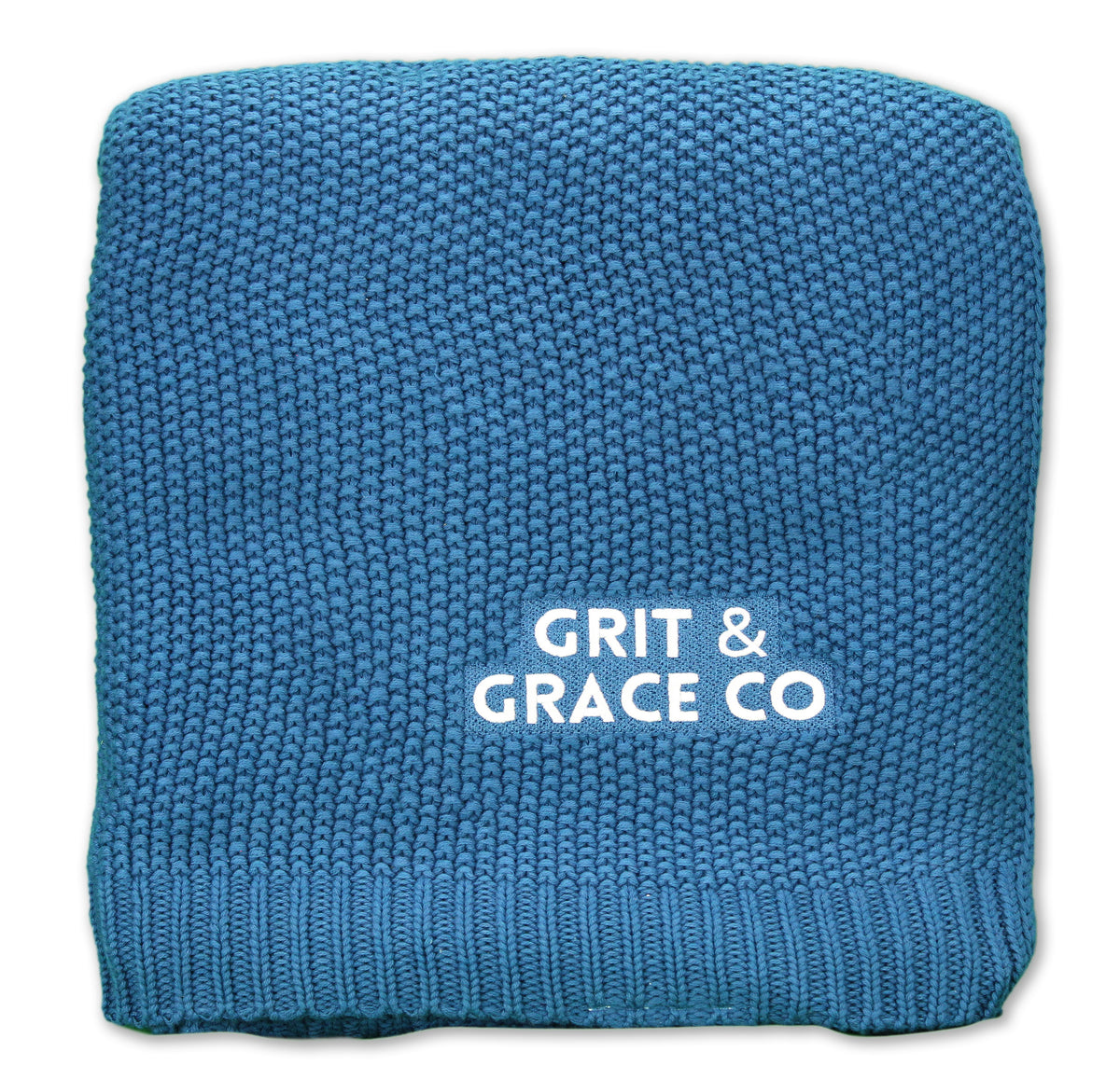 The Aliehs Crochet Knit Throw by Pro Towels is a blue blanket, neatly folded, with GRIT & GRACE CO printed in white on its surface.