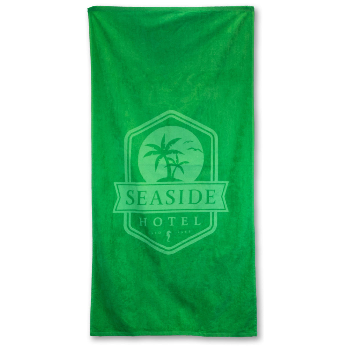 The Pro Towels Beach Towel - Platinum Collection is a green heavyweight cotton towel with a center logo of palm trees, birds, and Seaside Hotel text.