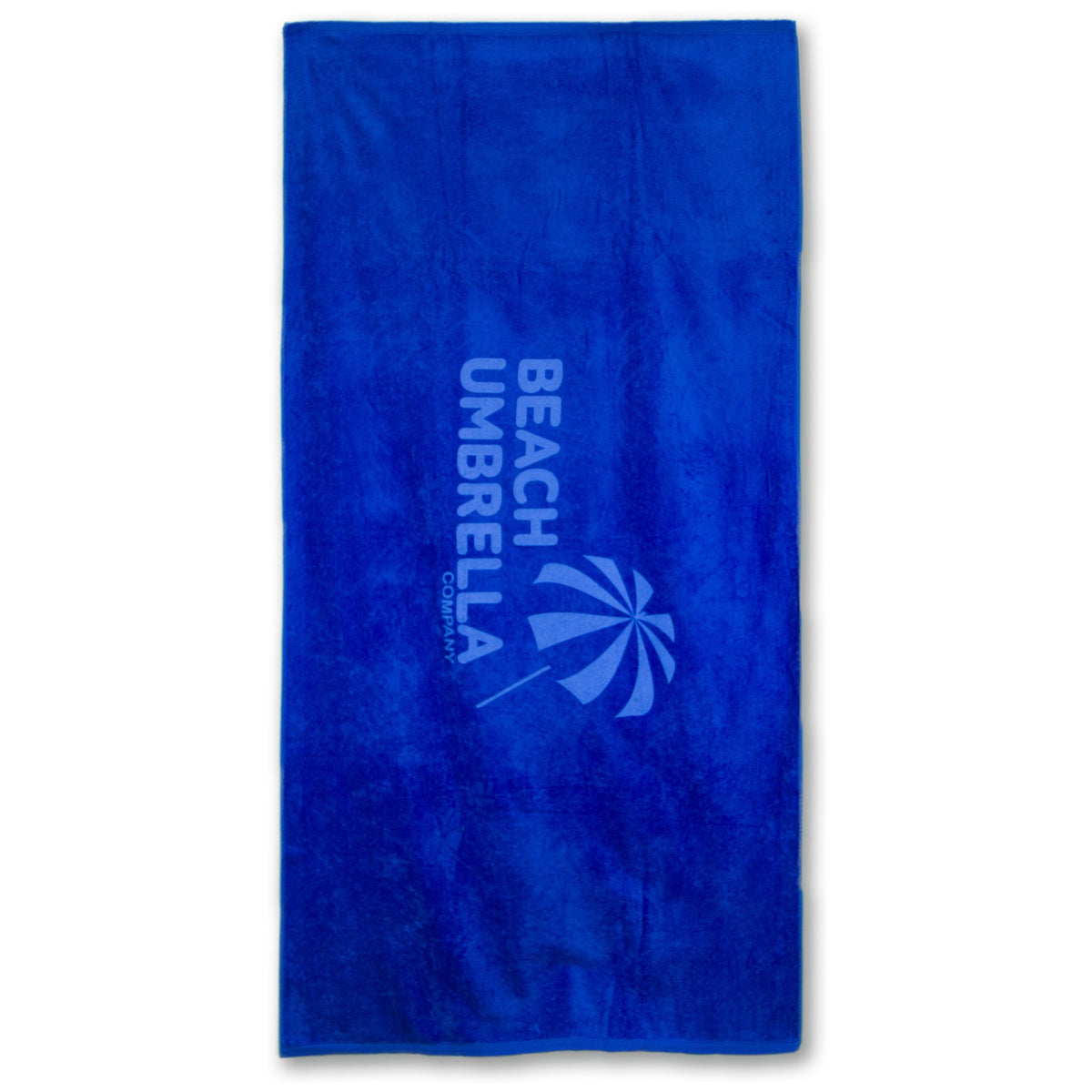 The Pro Towels Beach Towel - Platinum Collection is a rectangular, bright blue heavyweight cotton towel with BEACH UMBRELLA and an umbrella graphic printed in lighter blue on one side.