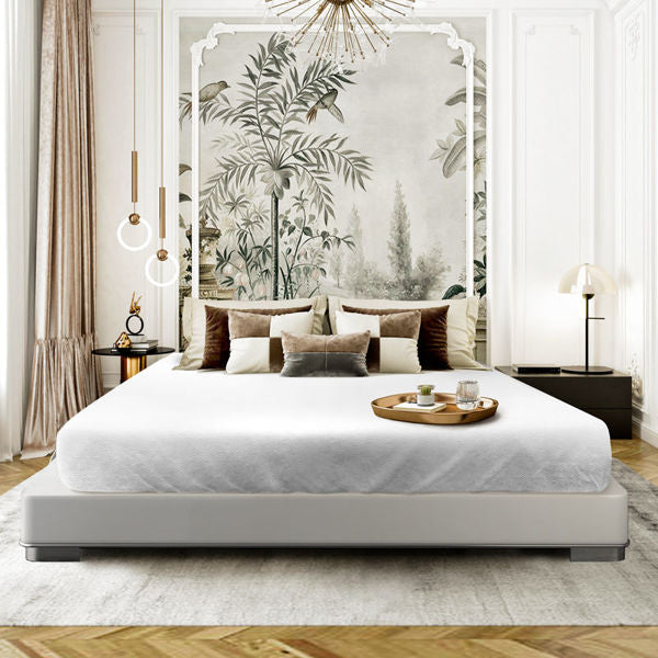 Elegant bedroom with a large bed featuring the Ganesh Mills Oxford Bed Topper - Jacquard Basketweave, decorative pillows, and a tray with tea set. A tropical plant wall mural, modern lighting, and calming tones enhance the stylish atmosphere.