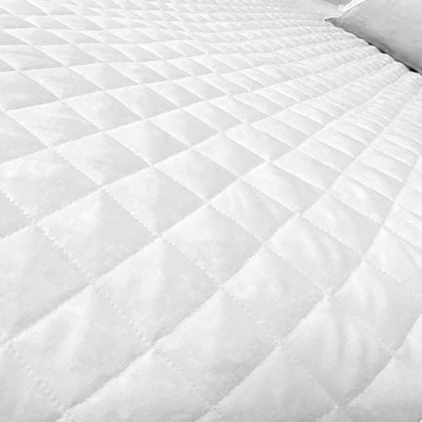 Close-up of the Ganesh Mills Diamond Check Quilted Bed Topper - Oxford Ultra Light Duvet/Coverlet, featuring a white square pattern and detailed stitching, with part of a pillow visible—ideal for wholesale bedding collections.