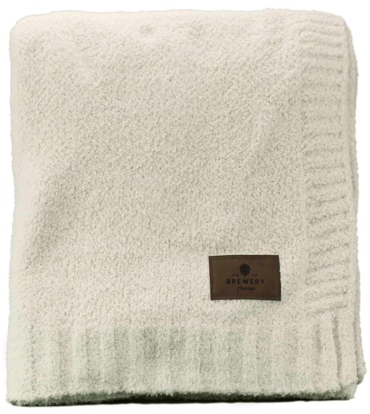 The Cloud Nine Soft Throw by Pro Towels is a folded, cream-colored plush microfiber blanket with a ribbed edge and brown leather patch—ideal for bulk wholesale or custom embroidery.