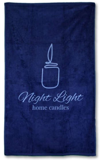 A colored beach towel from Pro Towels’ Diamond Collection features a simple candle outline over “Night Light home candles” in elegant light blue script—ideal for custom embroidery to suit your style.