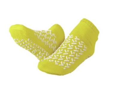 A pair of KSE Fall-Risk Slipper Socks in bright yellow with white grip patterns for fall prevention, shown on a plain white background.