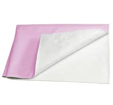 The Ganesh Mills Oxford Hospital Bed Pad in green/pink, shown with a folded corner revealing its white underside, provides dependable incontinence protection.