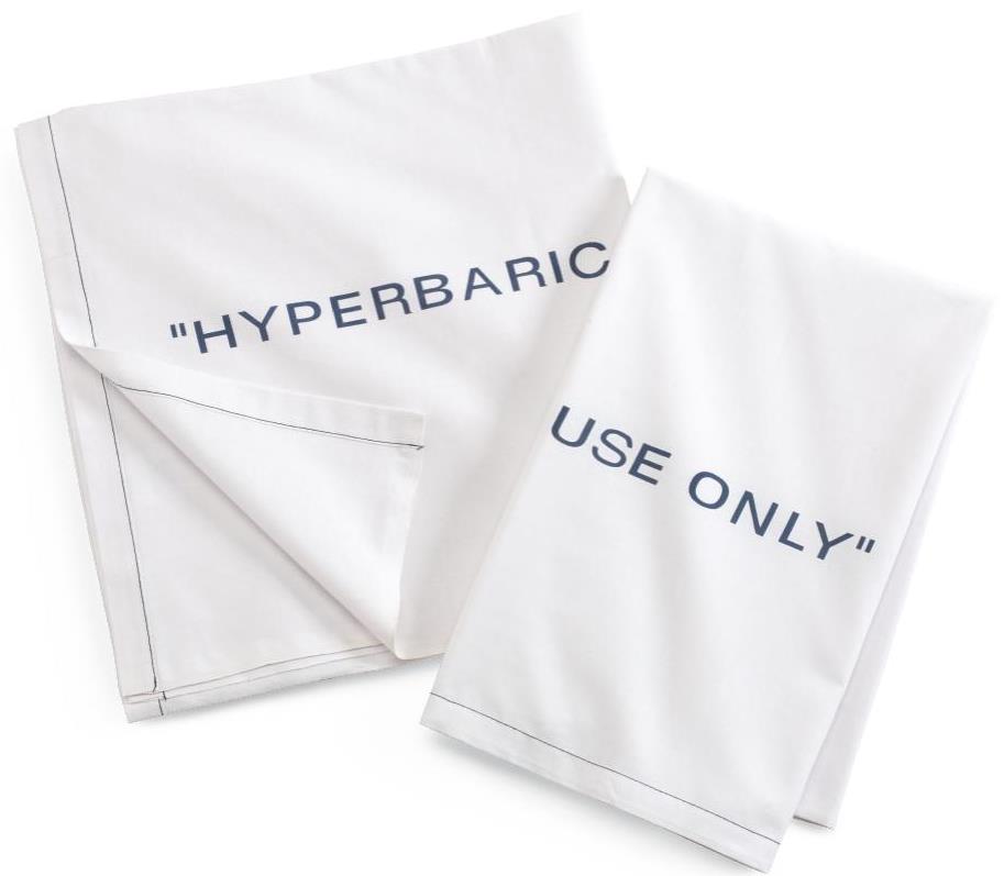 Two white KSE Hyperbaric Flat Sheets with dark blue text: one reads HYPERBARIC, the other USE ONLY. Both feature simple dark stitched borders and partially overlap.