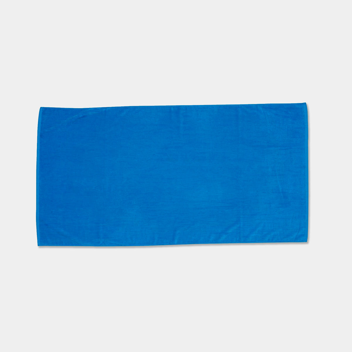The Pro Towels Beach Towel - Jewel Collection is a plain, rectangular blue towel laid flat on a white background—ideal for wholesale orders or custom embroidery.