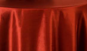 A close-up of a round table draped in the Ganesh Mills Oxford Round Table Linen - Multicolor, highlighting its smooth fabric, gentle folds, and light reflections.