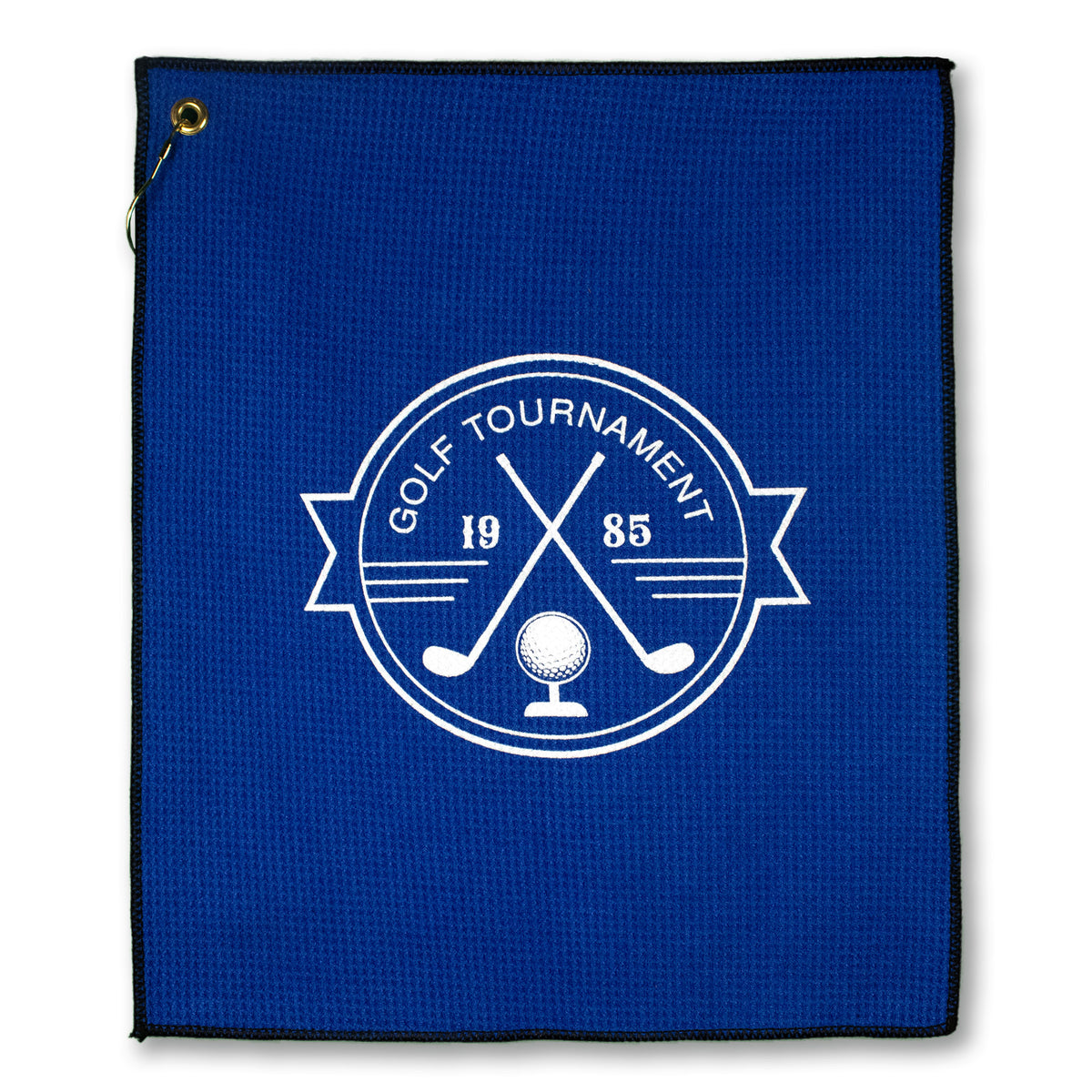 The Pro Towels Microfiber Waffle Small Golf Towel is blue with a white circular logo of two crossed golf clubs, a golf ball, and "GOLF TOURNAMENT 1985." Features a sturdy metal grommet in the top left corner.