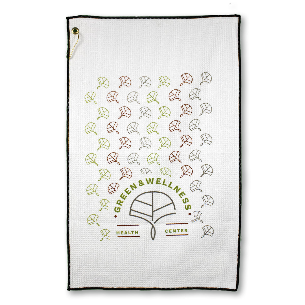 The Pro Towels Microfiber Waffle Golf Towel is white with a black border, features a tree design in green, brown, and yellow leaves above Green & Wellness Health Center, and includes a metal grommet and hook in the top left corner.