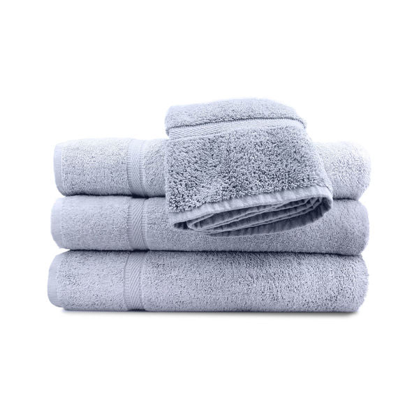 A stack of three light gray bath towels topped with a Ganesh Mills Hand Towel - Oxford Imperiale Color Towel, set against a white background.