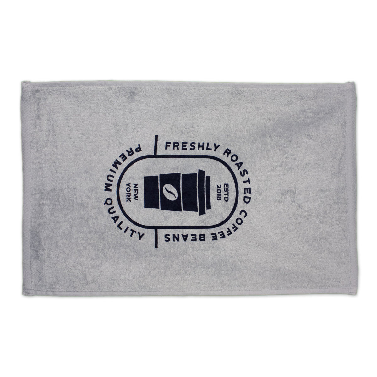 The Pro Towels Platinum Collection Golf Towel with Corner Grommet is light gray and rectangular, featuring a dark blue coffee cup graphic with Freshly Roasted Coffee Beans, Premium Quality, New York, ESTD 2019. Ideal for custom embroidery or promotions.