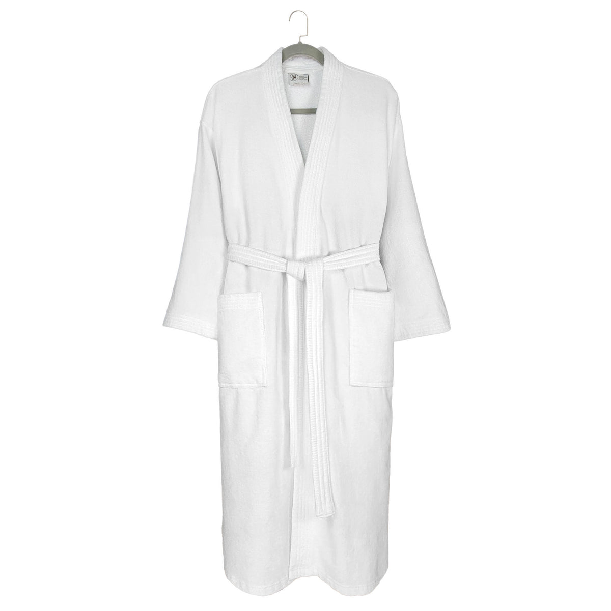The Kimono - White Oxford Velour Bathrobe by Ganesh Mills, featuring long sleeves, two front pockets, and a matching waist belt, hangs on a hook against a plain background.