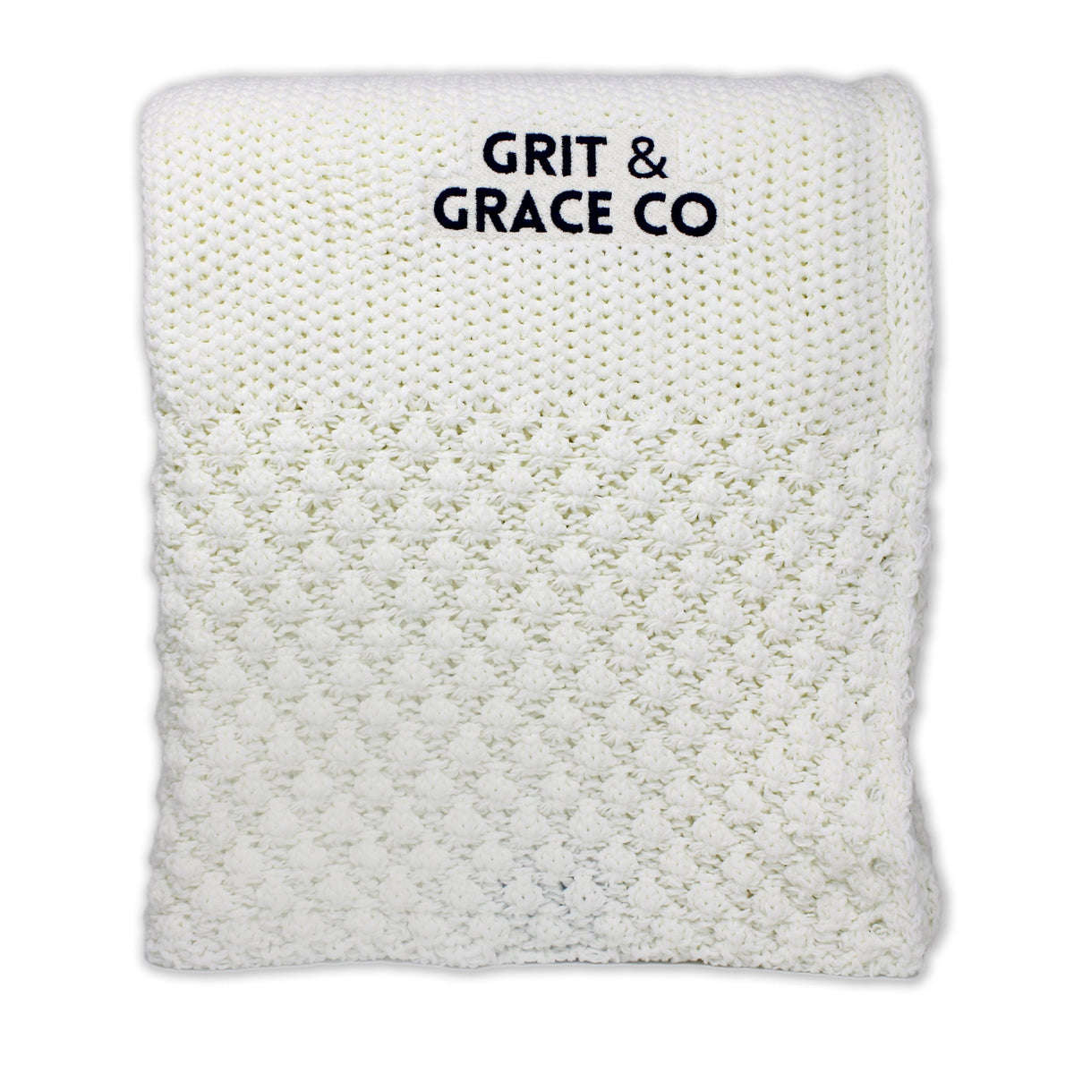 The Riviera Throw EnviroFibr by Pro Towels is a sustainable, white, textured blanket featuring custom black GRIT & GRACE CO embroidery on top—designed for stylish comfort.
