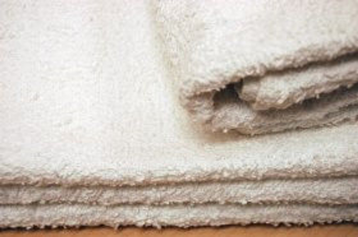 Close-up of several folded Rally Towels - White by Ganesh Mills stacked together, showcasing their soft and textured fabric.
