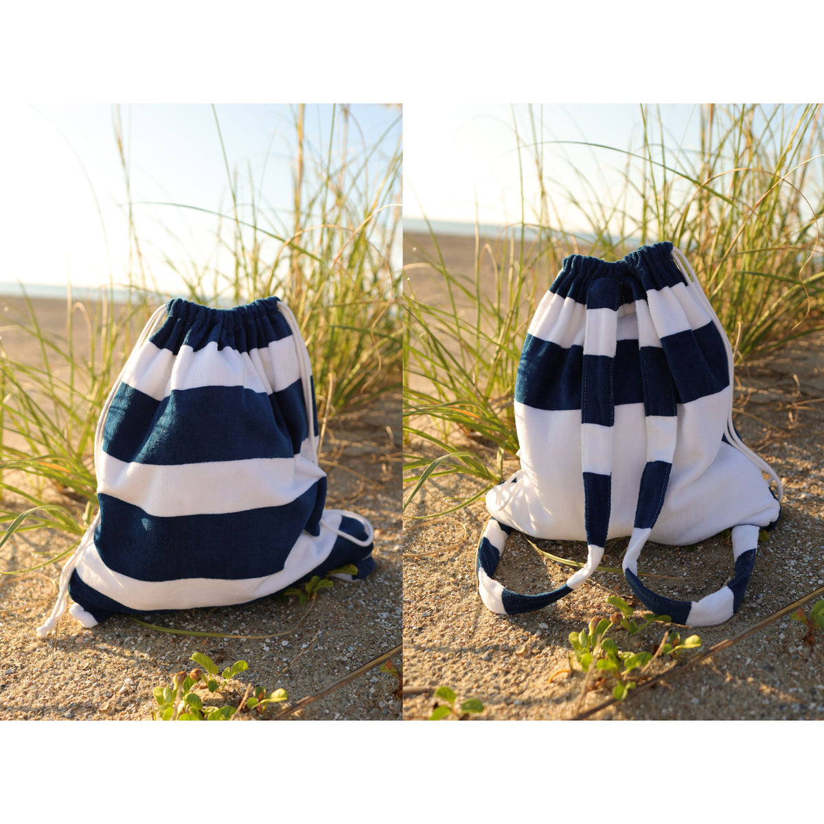 The Shore Buddy - Striped Cabana Beach Towel by Pro Towels is displayed on sandy ground near beach grass and the ocean, shown in warm sunlight from two angles, with a blue and white striped drawstring backpack beside it.