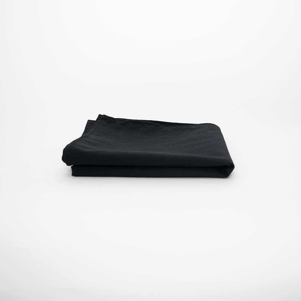 The Prisma Table Cloth by Calderon Textiles, renowned for its exceptional stain resistance, is neatly folded on a plain white surface with a minimalistic background.