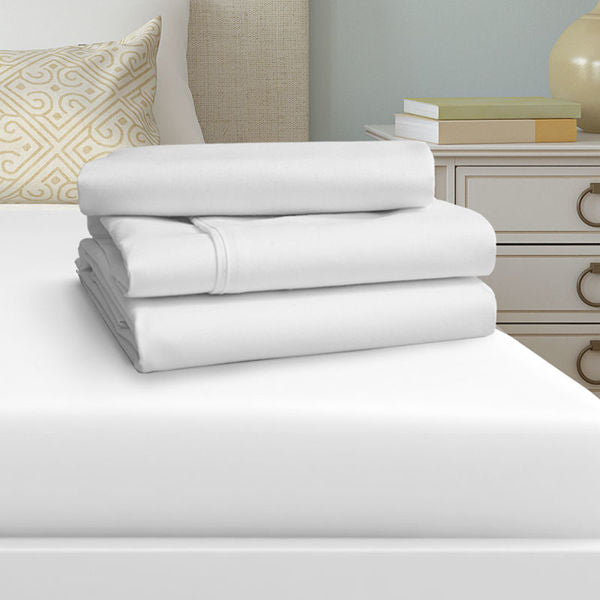 A neatly folded stack of Ganesh Mills Oxford T250 Satin Bed Linen Flat Sheets with 2 top hem and 1 bottom hem rests on a made bed, surrounded by luxe décor for an elegant, hotel-inspired bedroom feel.