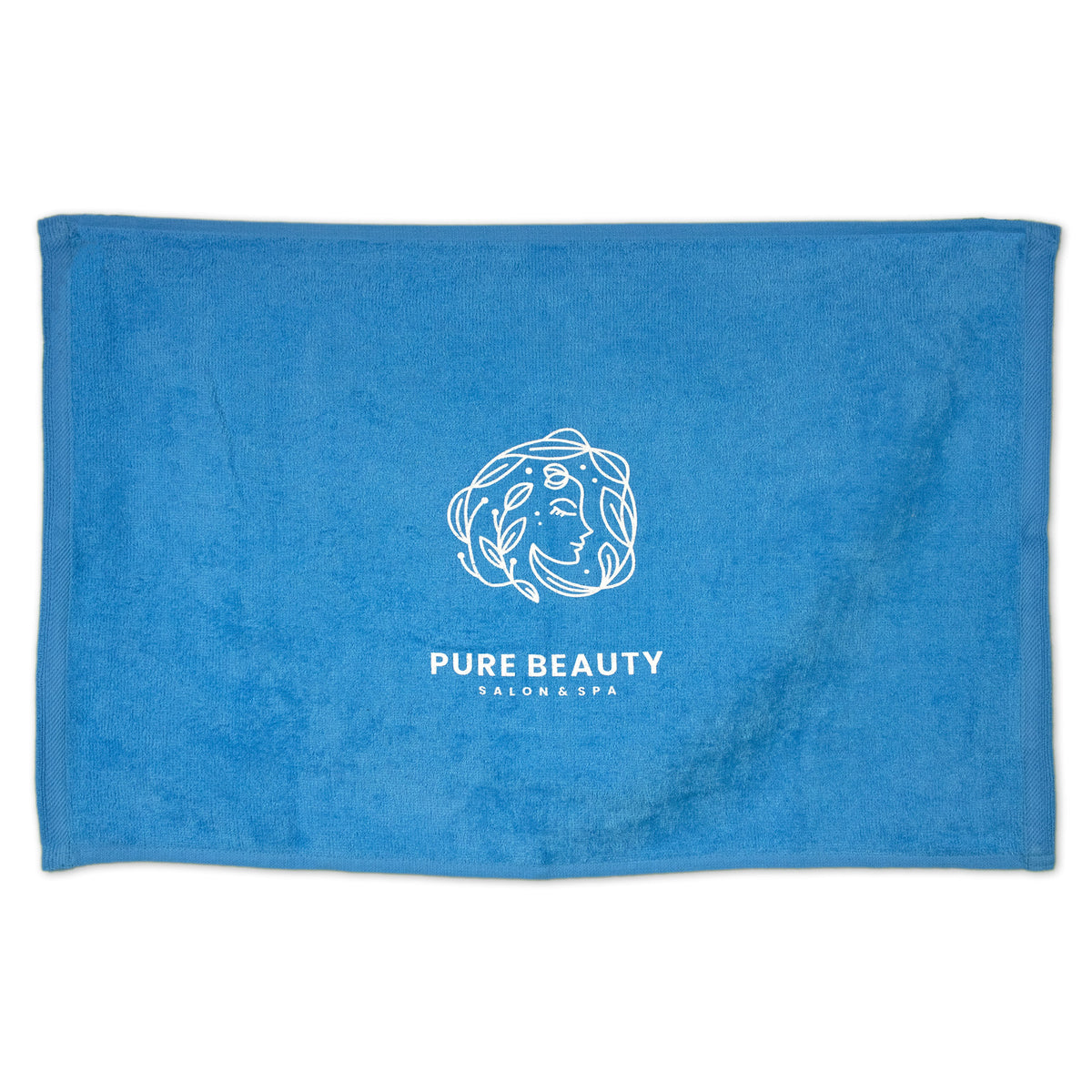 The Pro Towels Diamond Collection Sport Towel is bright blue, features a white line drawing of a woman's face with leaves and PURE BEAUTY SALON & SPA text—ideal for custom embroidery or as a stylish rally towel.