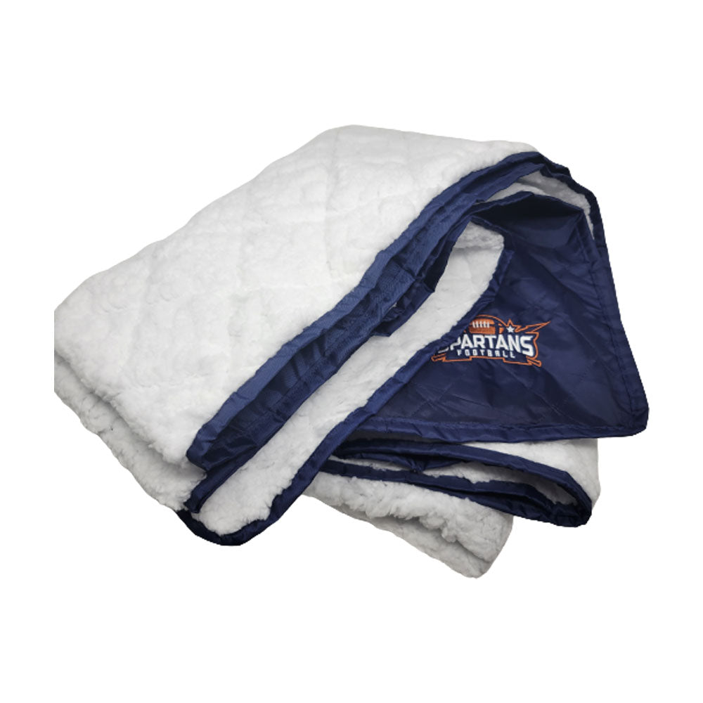 The Pro Towels Waterproof Sherpa Blanket is folded, white with a navy satin edge, and features custom orange and white Spartans Football logo embroidery—ideal as an outdoor game day blanket.
