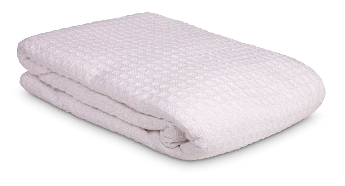 The KSE Waffle Weave Blankets, crafted from white cotton with a textured waffle pattern, are shown neatly folded on a white background—ideal for those needing premium or wholesale blankets.
