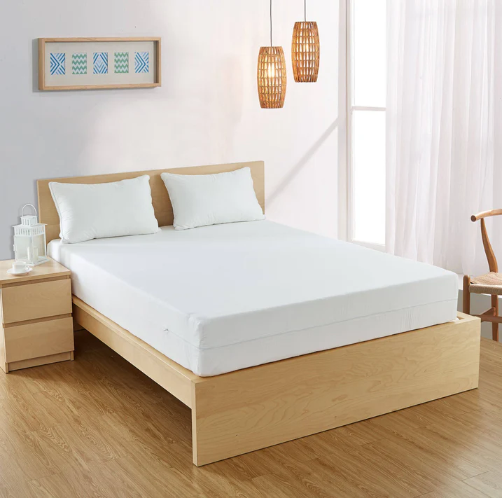 A modern bedroom with a light wood bed frame, white mattress in the Bargoose AllergyCare Cotton Zippered Mattress Encasement (9 deep) for bed bug protection, two white pillows, a matching nightstand with a lantern, wicker pendant lights, wooden chair, and sheer curtains.