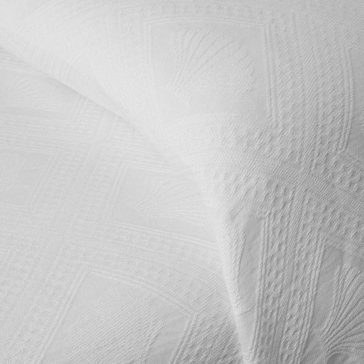 Close-up of two Avalon Jacquard Bedspreads by Bargoose, featuring a white embossed geometric and shell-like design that highlights the fabrics softness—an ideal choice for luxurious hotel bedding.