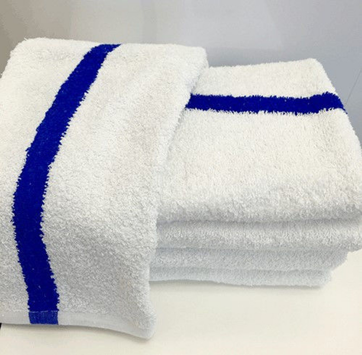 The 1Concier Bath Towel Blue Center Stripe Pool Towels, made from 100% cotton absorbent loops, feature a bold blue center stripe and are neatly folded on a white surface against a plain background.