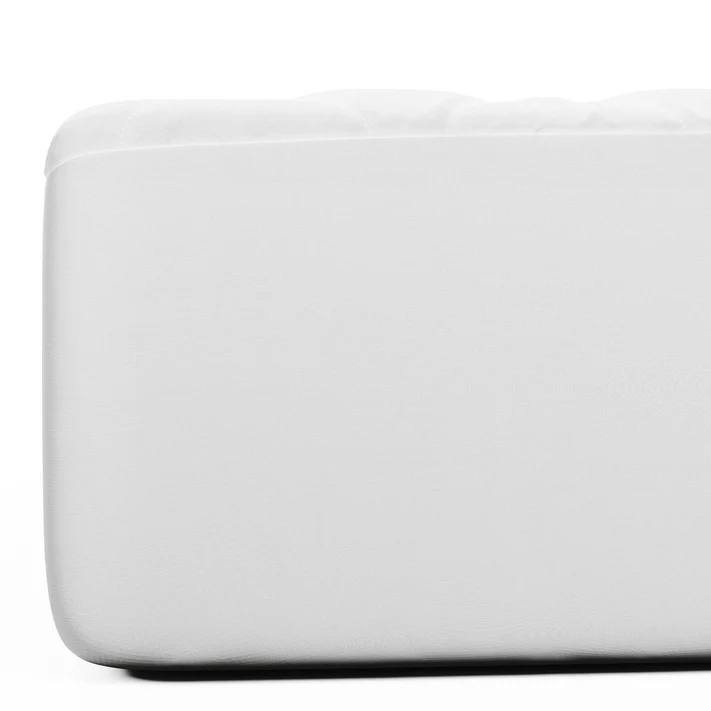 Close-up of the corner of a white Bargoose Deluxe Microfiber Waterproof Quilted Mattress Pad with a 16" fitted skirt, shown on an air mattress against a plain white background.