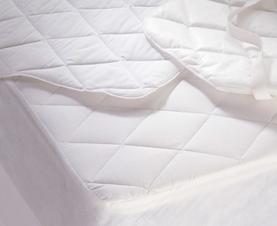A close-up of the 1Concier Mat Pad Silver Star shows its white, diamond quilted design with anchor bands visible on top, partially covering a mattress along with another quilted fabric piece.