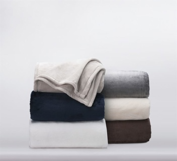 A stack of six 1Concier Blanket Plush Blankets in beige, gray, navy blue, white, dark brown, and light gray neatly arranged highlights their luxurious silky texture.