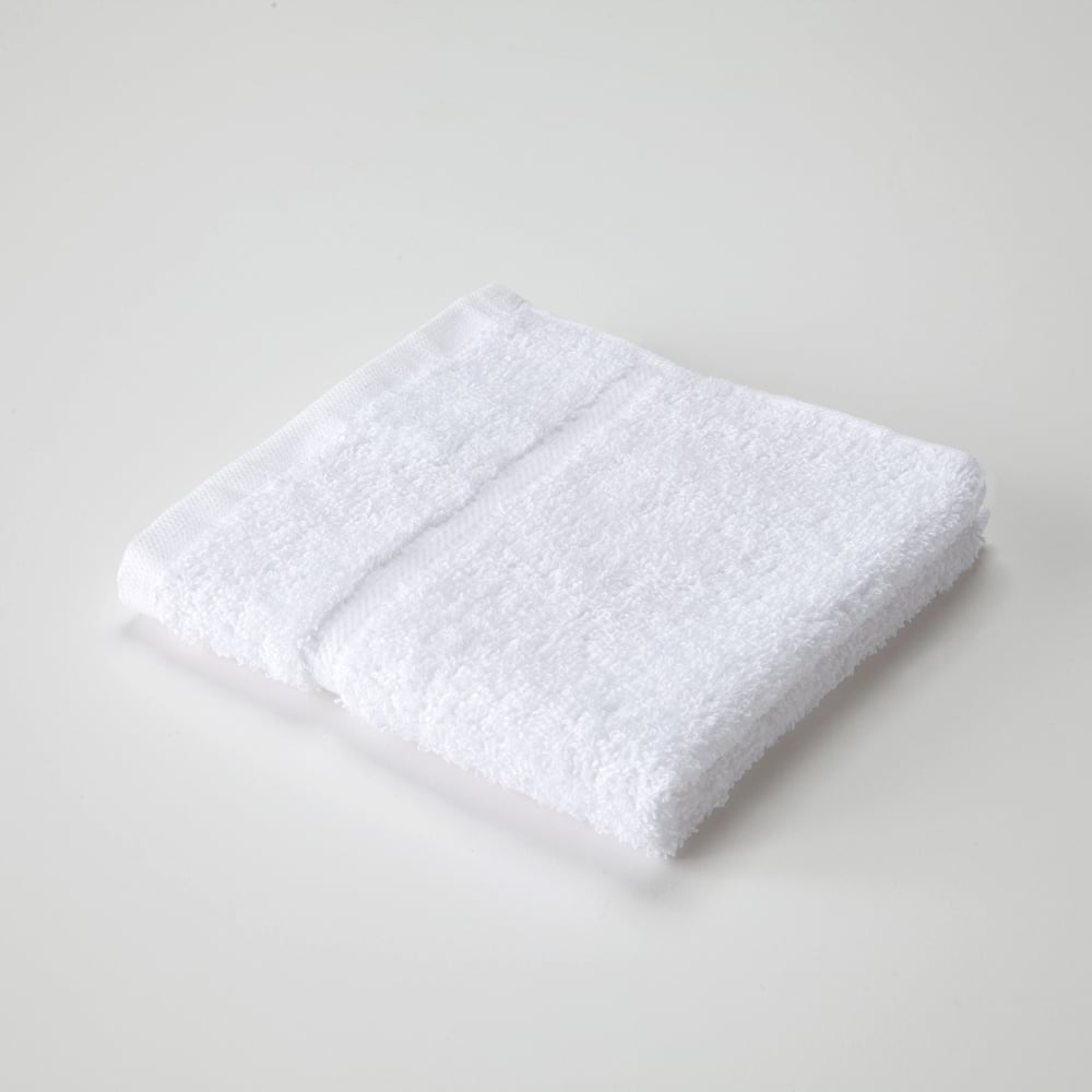 The Dobby Towel - Martex Sovereign by WestPoint Home, featuring a simple border and crafted for superior durability, is folded and placed on a plain, light-colored surface.