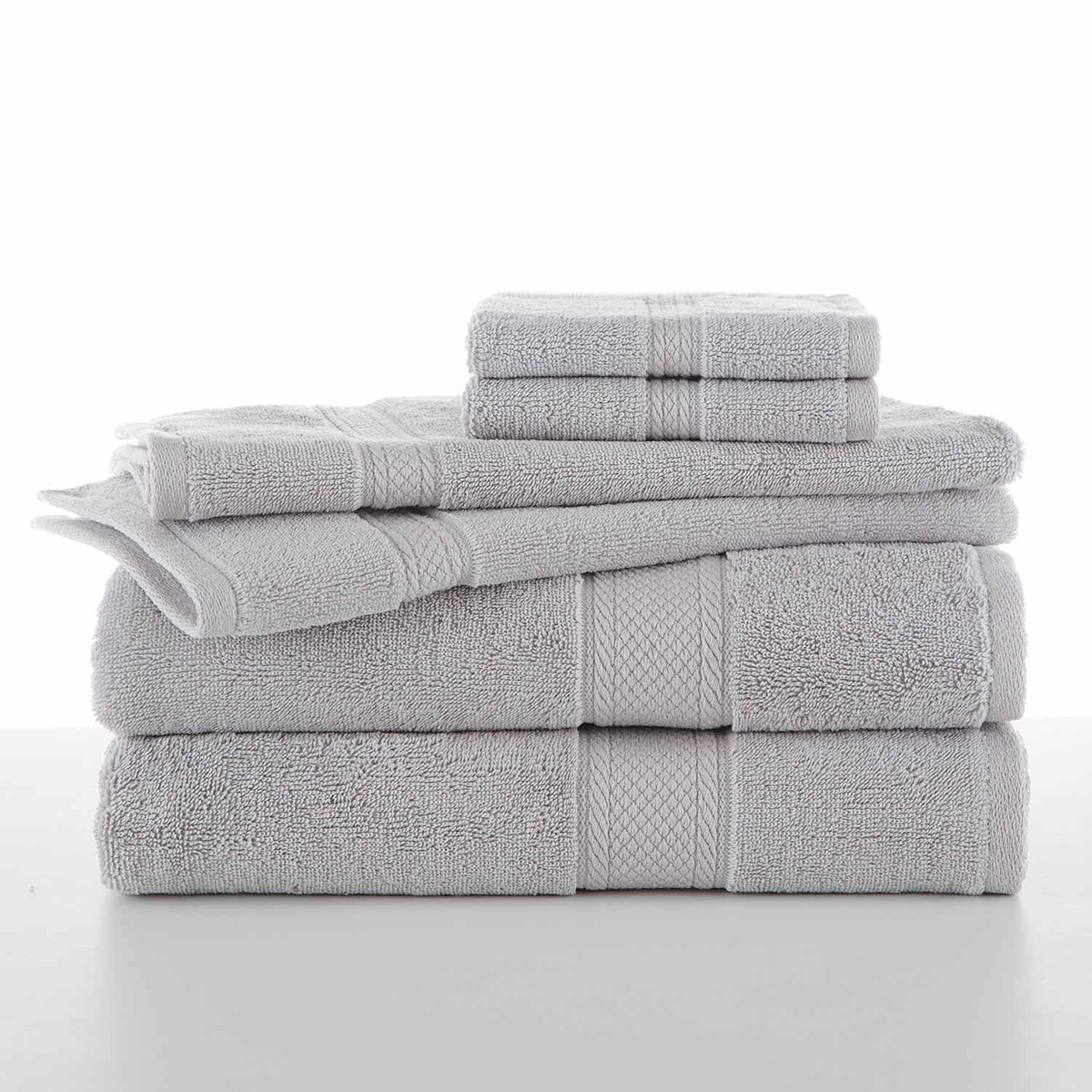 A neatly stacked set of WestPoint Home Grand Patrician Suites Dobby Towels in light gray, crafted from ring-spun cotton with subtle textured bands, arranged on a white surface against a white background.