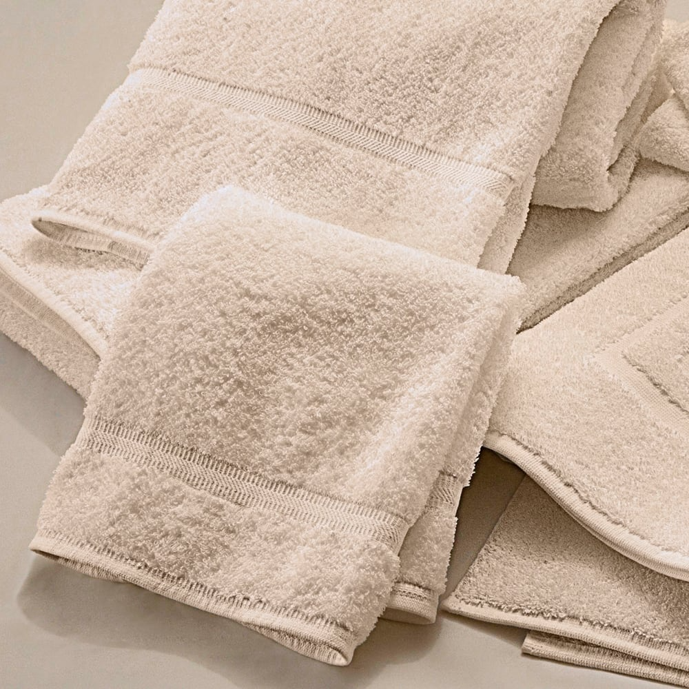 A stack of soft, durable Dobby Towels from WestPoint Home’s Martex Sovereign collection in off-white or beige cotton, neatly folded to display their superior texture.
