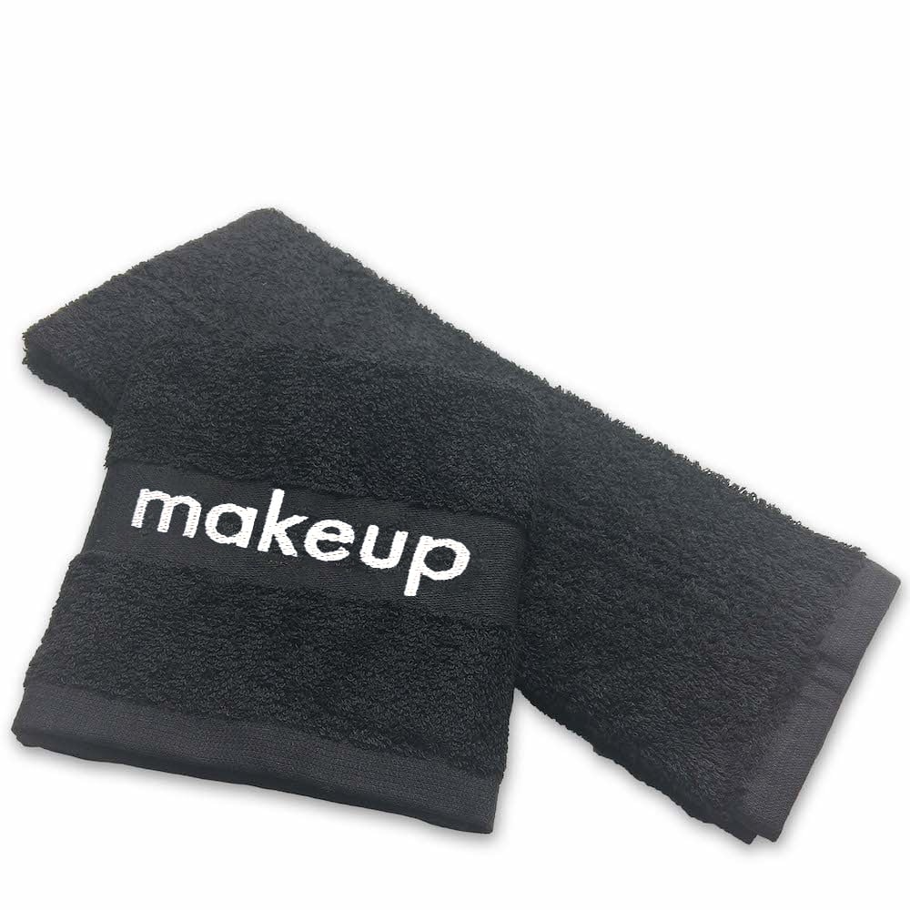Two black Martex Spa Makeup Removal Wash Cloths by WestPoint Home are shown, with one folded atop the other. The top cloth has makeup embroidered in white and features fade-resistant technology. The background is plain white.