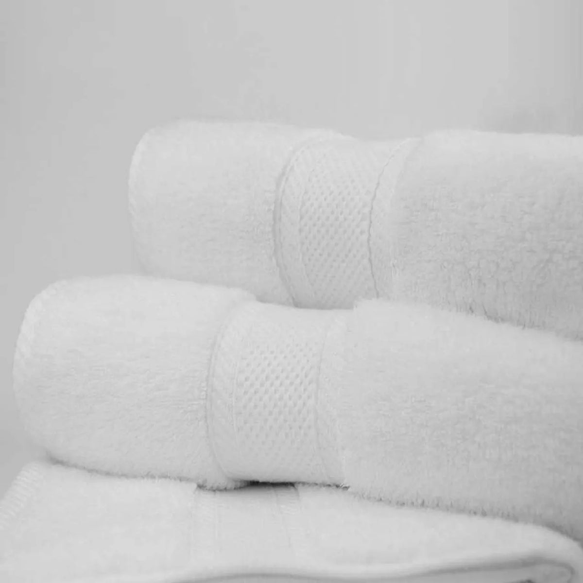 A white Bathmat from the Ganesh Mills Oxford Miasma Towel collection, crafted with zero twist cotton, is displayed against a plain white background—evoking the plush feel of luxury hotel linens.