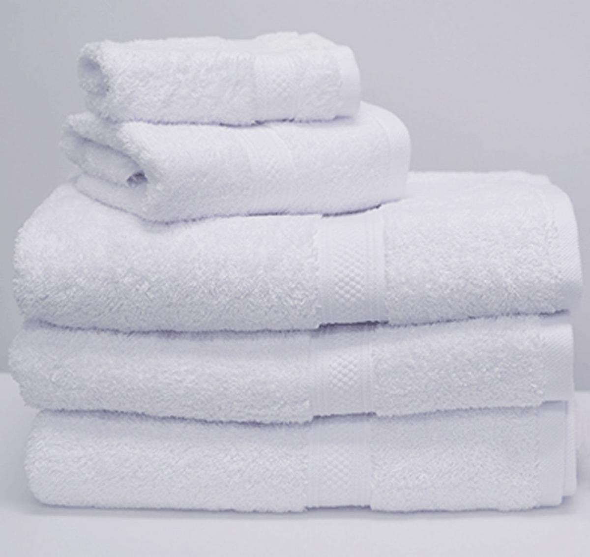 A neatly arranged set of 1Concier Bath Towel Pima Terry towels, made from 100% soft Pima cotton in various sizes, displayed against a plain light background.