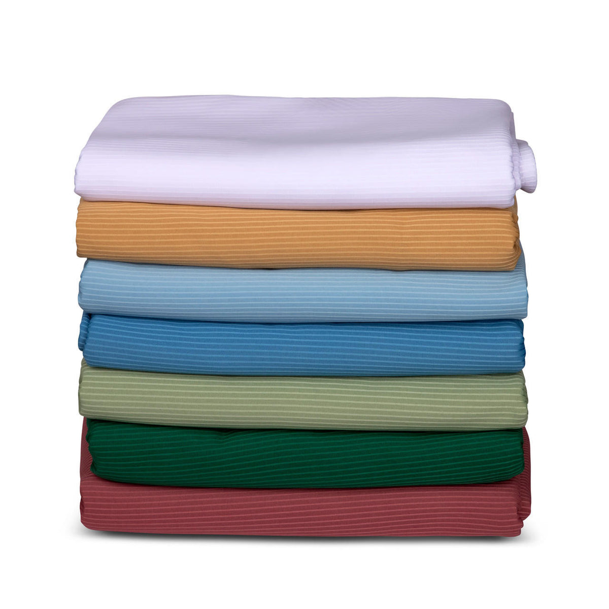 A neatly stacked pile of folded KSE Ribcord Bedspread fabric in seven colors—white, tan, light blue, blue, green, dark green, and maroon—arranged from top to bottom on a white background; ideal for wholesale bedding needs.