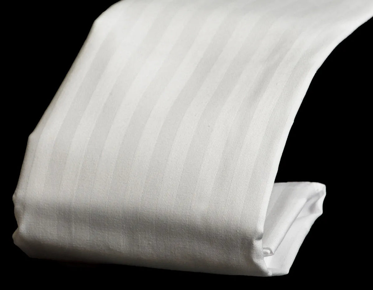 A neatly folded Thomaston Mills Wide Stripe napkin, 250 thread count satin stripe in white combed cotton-polyester blend, displayed against a black background.