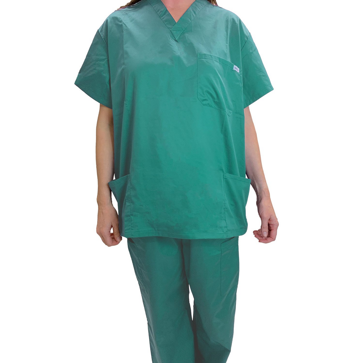 A person in WestPoint Home’s Martex Health Classic Scrub Top and matching pants stands against a white background. The short-sleeved V-neck top features pockets. The person’s head is not visible.