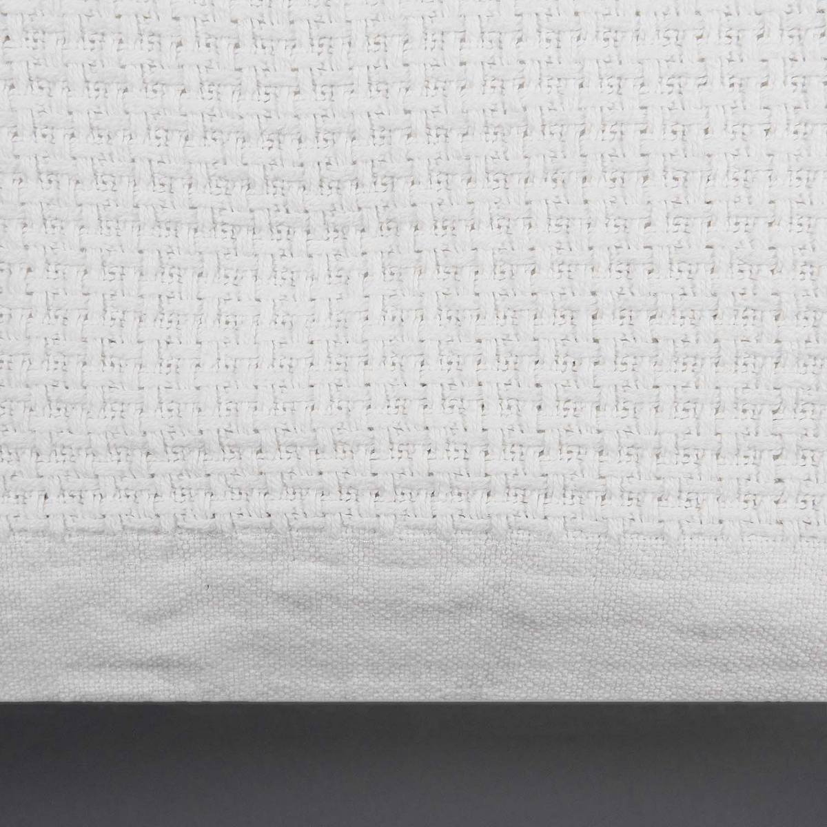 Close-up of the Sovereign - Cotton Blanket by WestPoint Home, featuring a white cotton textured grid pattern and smooth solid border—ideal for hospitality use or wholesale blanket needs.