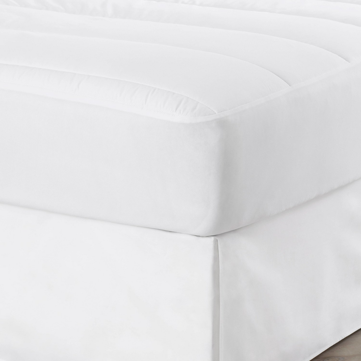 Close-up of a neatly made bed with The Clean Essentials T200 Pillow Protector No Peek by WestPoint Home, featuring smooth, clean fabric and soft, padded texture—crafted from OEKO-TEX certified materials for sustainable hospitality bedding.