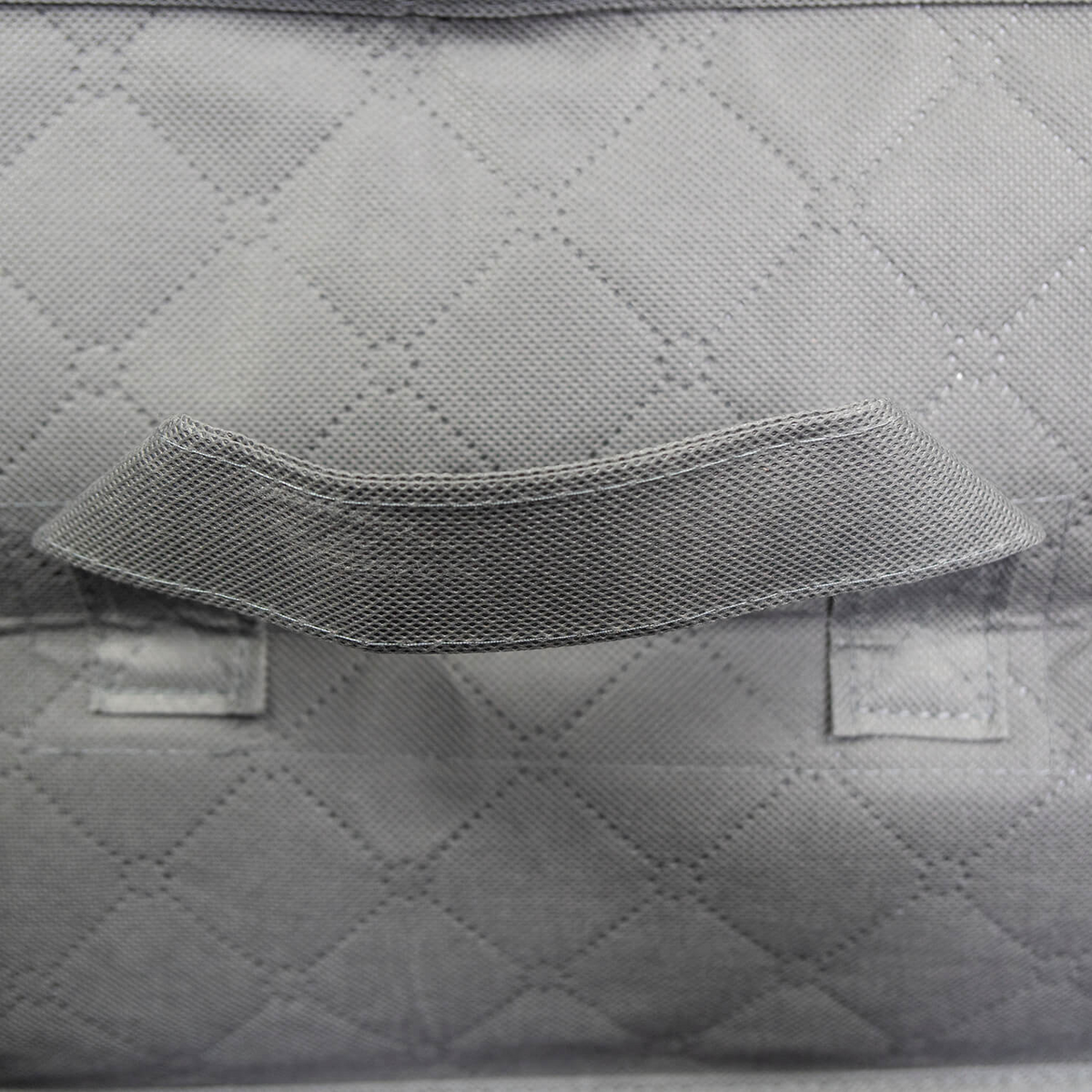 Close-up of the Martex Basics Closet Storage Bag by WestPoint Home, featuring gray quilted fabric with a diamond pattern and a stitched rectangular handle at the center, highlighting its durable, detailed construction.