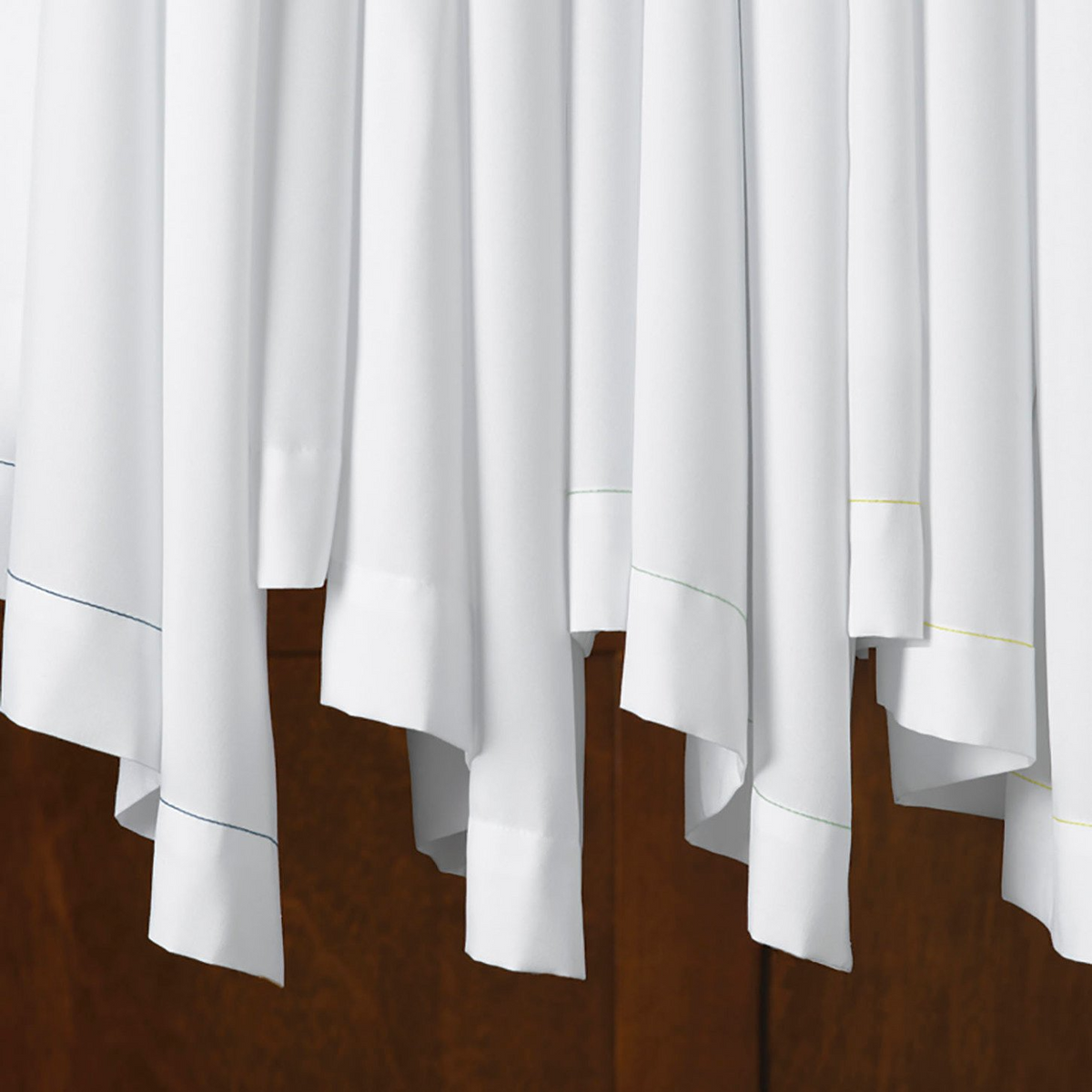 Martex Ultra Touch pillow cases by WestPoint Home feature classic percale weave and subtle colored stitching along the hem, displayed over a wooden surface that highlights their crisp, hospitality-inspired style.