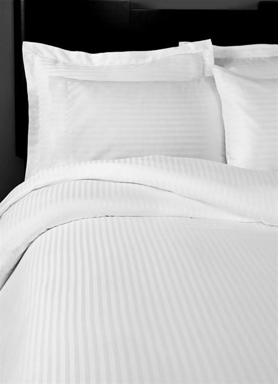A neatly made bed features the 1Concier Fitted Sheet Poly Sateen Stripe T300—crisp white, high thread count sheets and pillowcases offering easy-care luxury against a dark headboard.