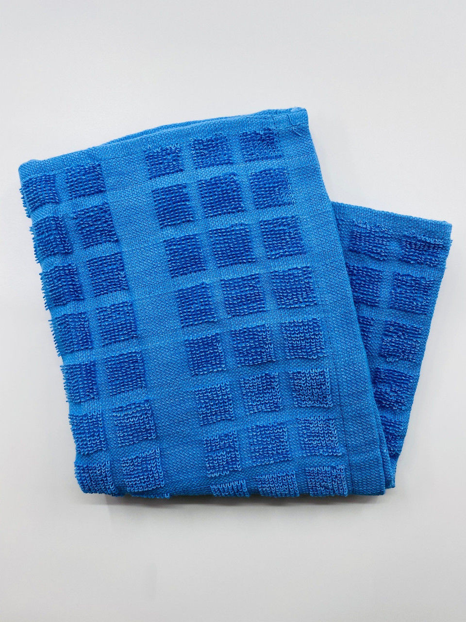 A checkered pattern blue dishcloth from the Ganesh Mills Oxford Kitchen Ensemble rests folded on a plain white surface.