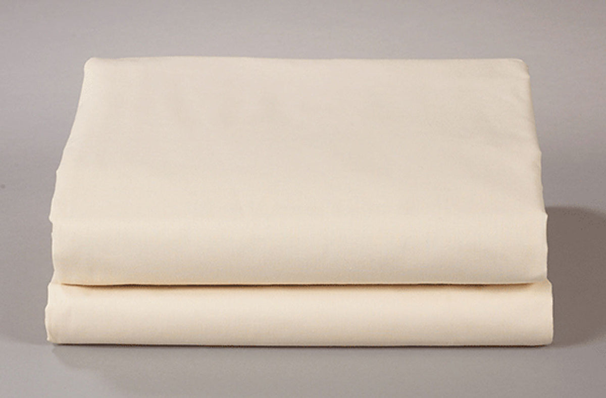 A neatly folded set of Thomaston Mills Pillowcases - Single Pick Percale in off-white is displayed on a plain light surface, highlighting reliable hospitality bedding.