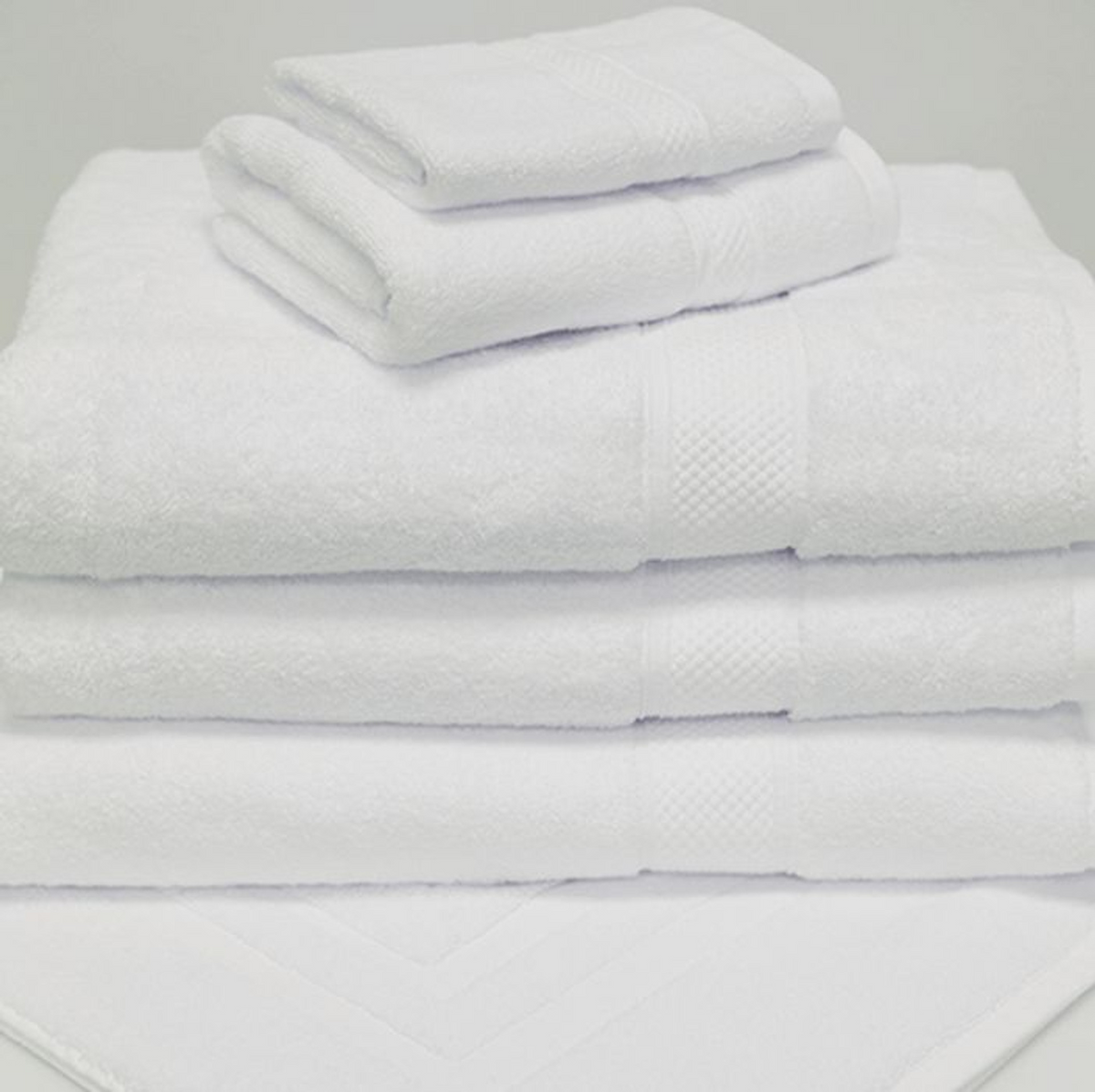 A neatly folded stack of 1Concier Bath Mat Orchid Terry Cotton/Rayon towels is arranged on a clean, white surface, with two small towels placed atop larger bath mats.