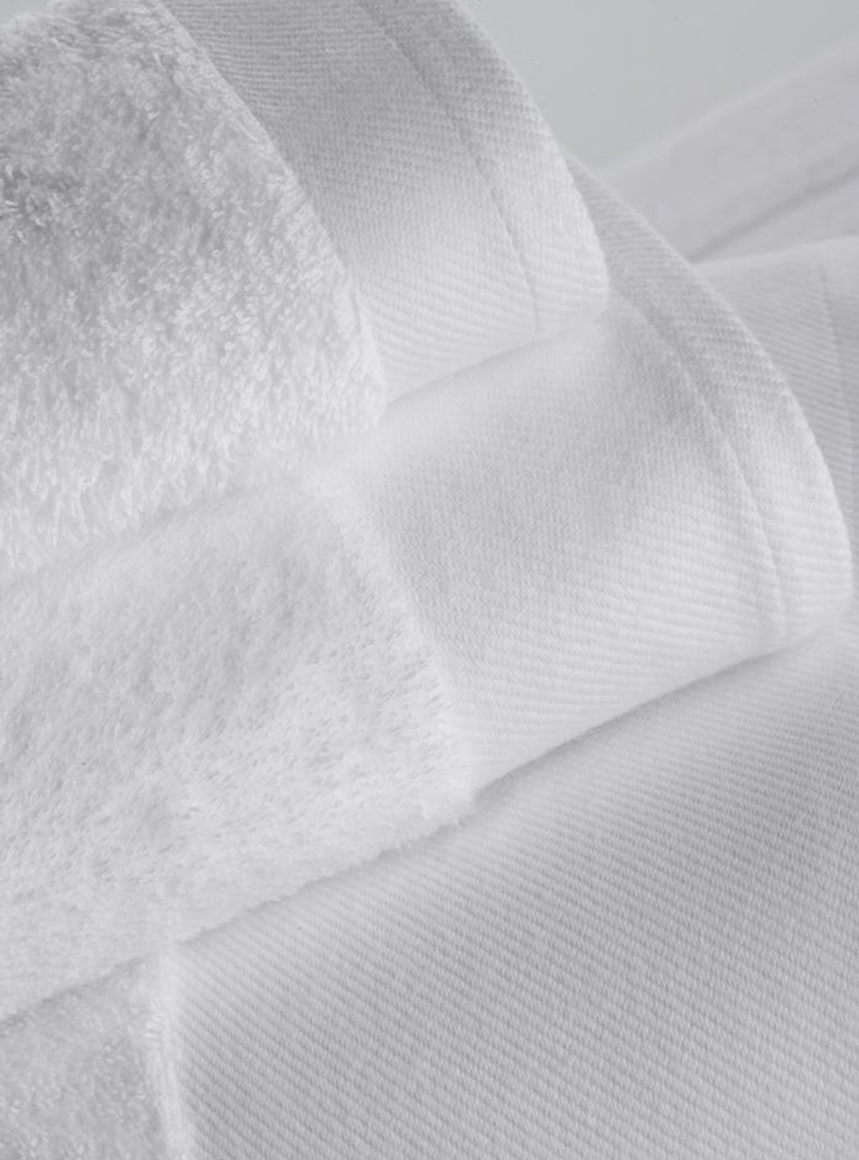 Close-up of neatly folded, white Bath Sheet Shore Terry 100% Cotton towels by 1Concier, stacked to highlight their plush texture, crisp look, and elegant oversized jacquard hem.